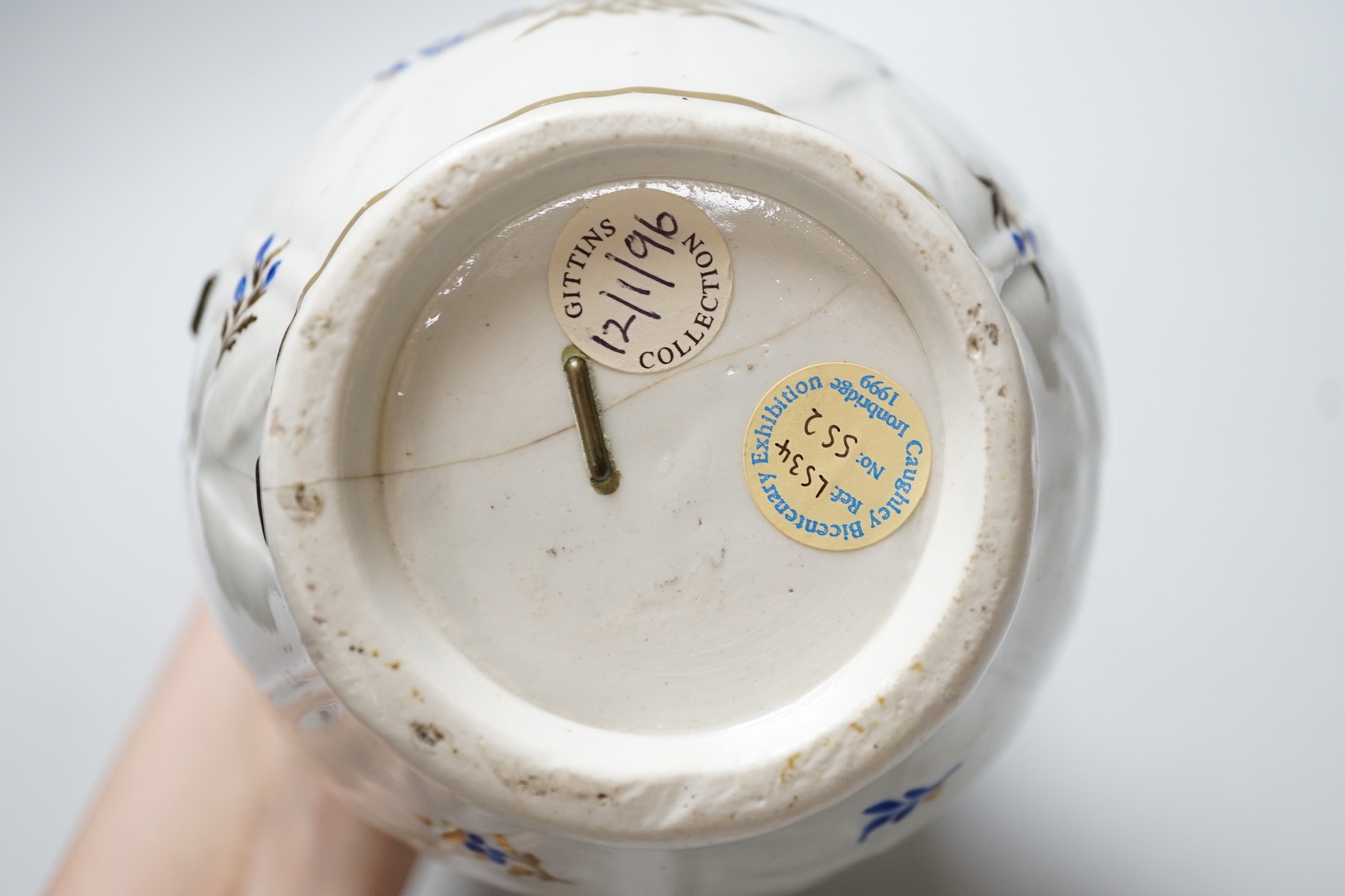 An 18th century Caughley very rare polychrome mask jug, elaboratley painted and gilded with two initials in a dry blue and gilt wreath, Gittins Col., Pictured Caughley Bicentenary Exhibition 1999, with labels, 19cms high